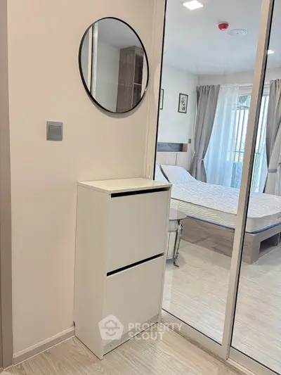 Modern bedroom with mirrored wardrobe and sleek white furniture
