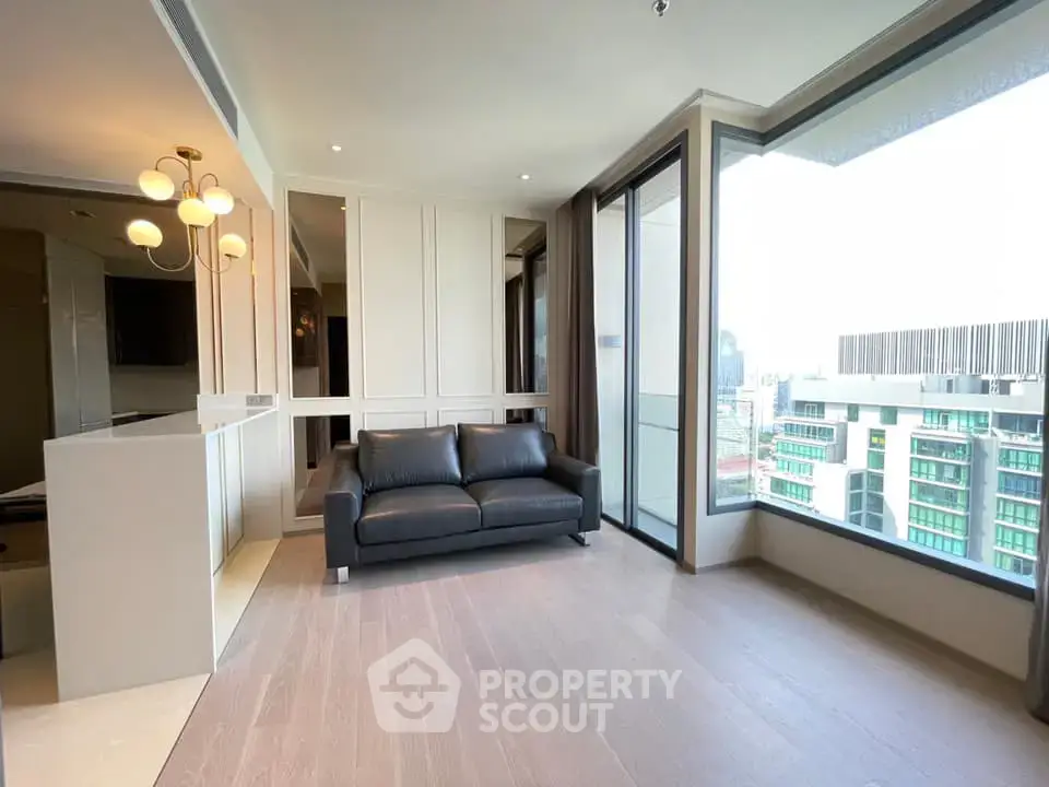 Spacious modern living room with large windows and city view, featuring elegant lighting and sleek flooring.