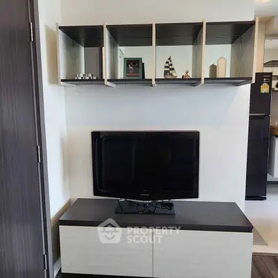 Modern living room with sleek TV stand and wall-mounted shelves in stylish apartment.