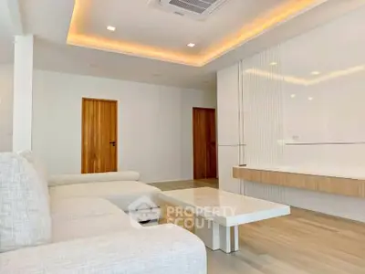 Modern living room with sleek design, featuring a cozy sectional sofa and elegant lighting.