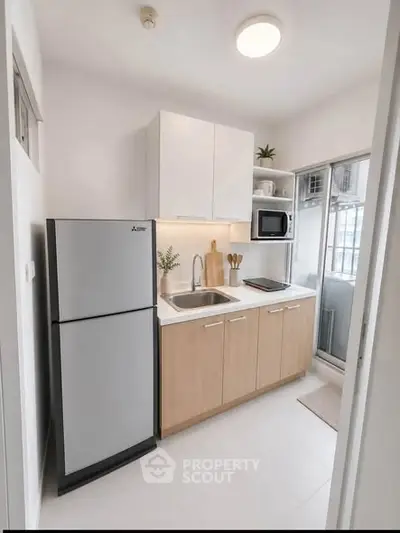 Modern compact kitchen with sleek appliances and minimalist design