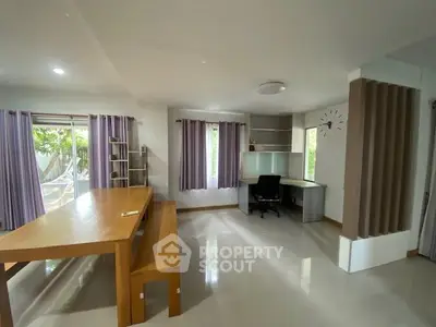 Spacious study room with modern desk and large windows in a serene home setting.