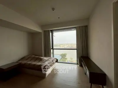Spacious bedroom with large window offering stunning city and river views.