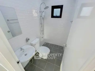 Modern bathroom with sleek white tiles and contemporary fixtures.