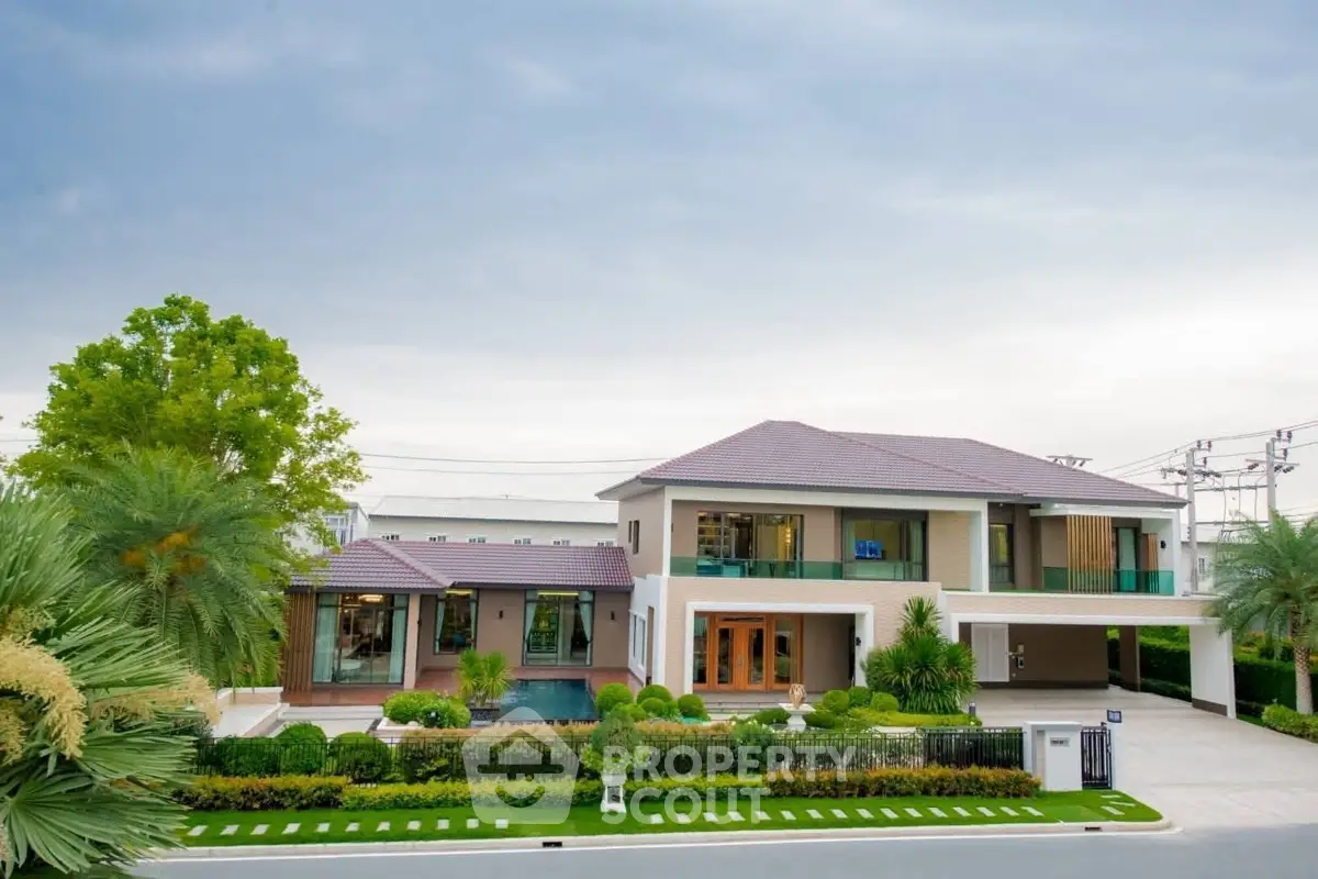 Luxurious modern villa with lush garden and spacious driveway, perfect for upscale living.
