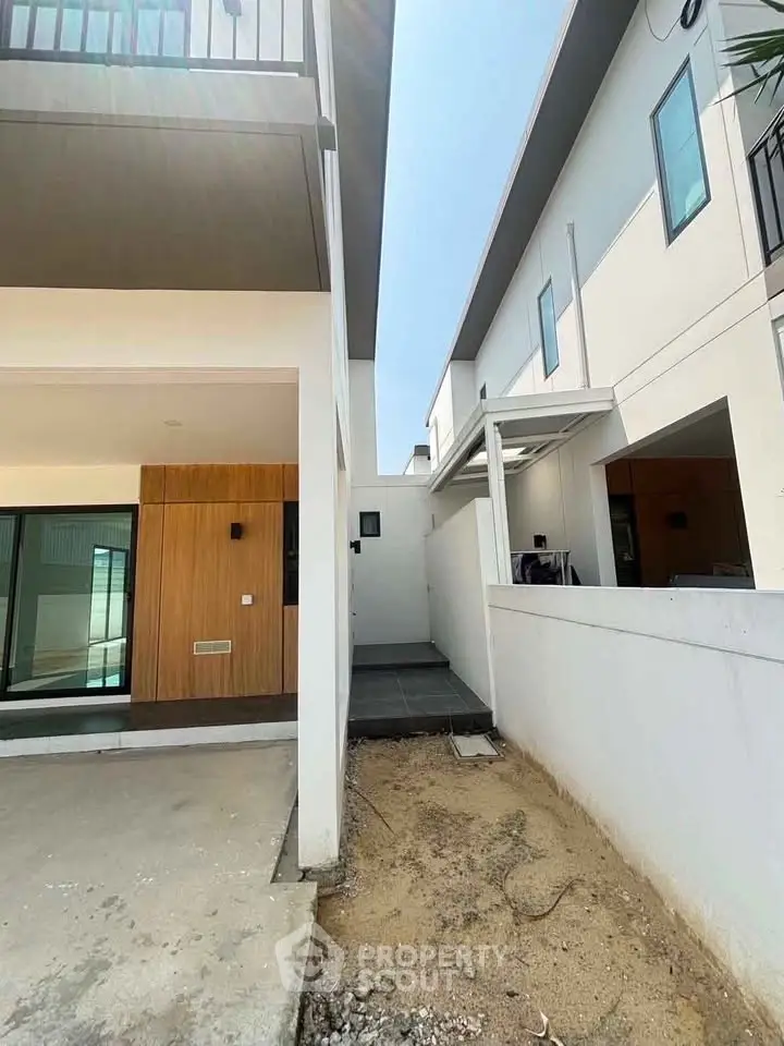 Modern townhouse exterior with clean lines and minimalist design, showcasing a spacious driveway and contemporary architecture.