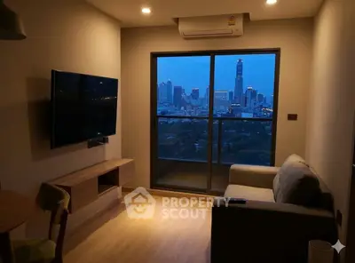 Modern living room with city view, featuring a wall-mounted TV and cozy seating area.