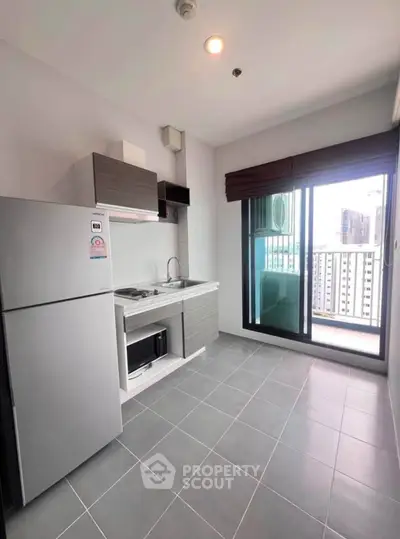 Modern kitchen with sleek appliances and balcony view in urban apartment