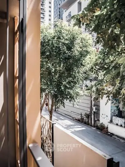 Charming urban view from a cozy balcony with lush greenery and modern architecture.