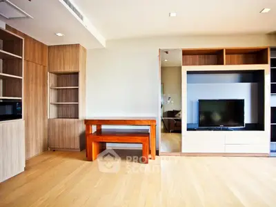 Spacious modern living room with built-in wooden cabinets and entertainment center.