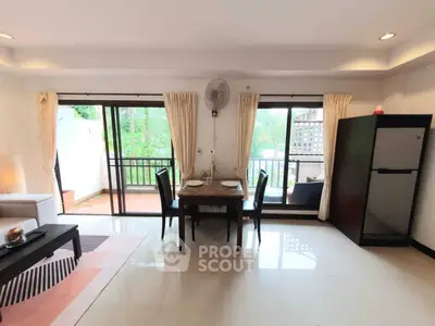 Spacious living room with dining area and balcony view in modern apartment