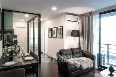 Modern living room with dining area, featuring sleek furniture and large windows for natural light.
