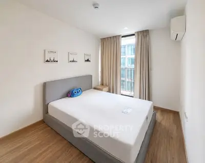 Modern bedroom with large window and minimalist decor in urban apartment