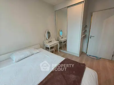 Cozy bedroom with elegant vanity and mirrored wardrobe in modern apartment.