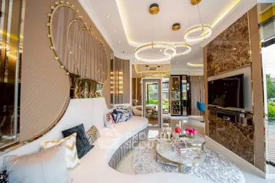 Luxurious living room with elegant decor and modern lighting, featuring plush seating and stylish marble accents.