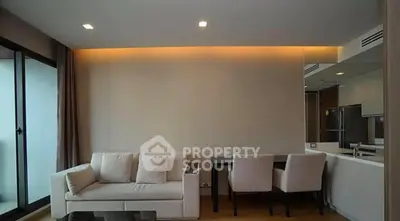 Modern living room with sleek design and open layout, featuring a cozy sofa and dining area.