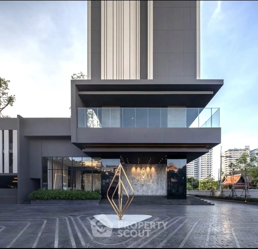 Modern building exterior with sleek design and geometric sculpture in front