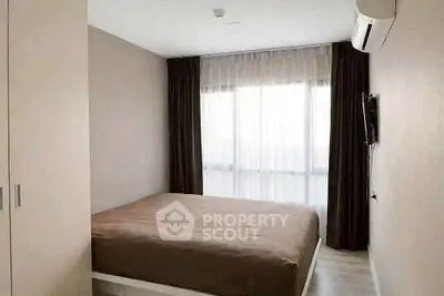 Cozy bedroom with large window and modern air conditioning unit, perfect for relaxation.