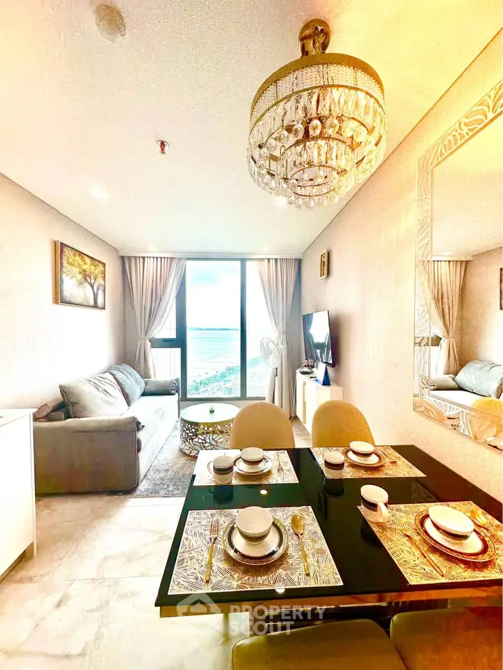 Luxurious living room with elegant chandelier and stunning ocean view, perfect for sophisticated living.