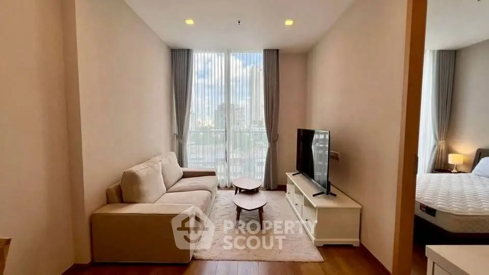 Modern living room with cozy sofa and large window offering city view.