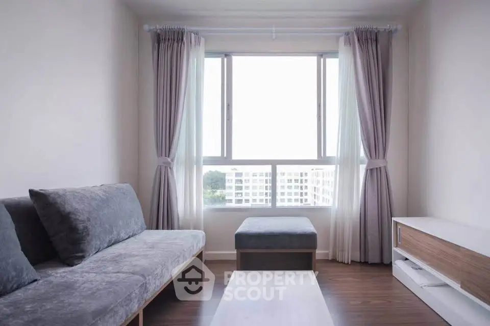 Cozy living room with modern sofa and large window offering natural light