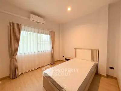 Spacious bedroom with natural light and modern furnishings in a stylish apartment.