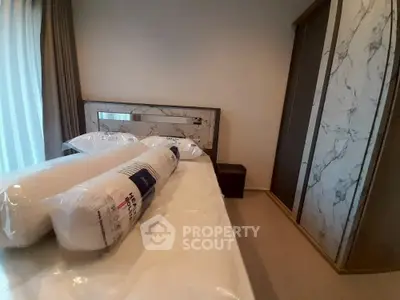 Modern bedroom with marble accents and new bedding in a stylish apartment.