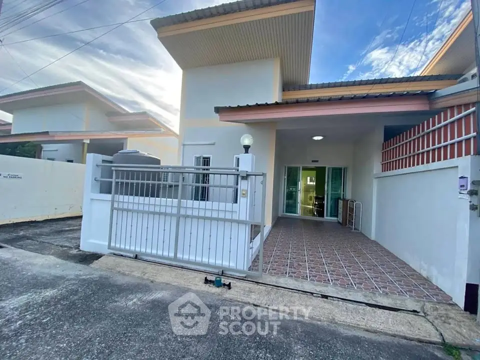 Charming single-story house with gated entrance and tiled patio, perfect for cozy living.