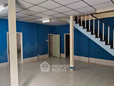 Spacious interior with blue walls and staircase, ideal for customization.