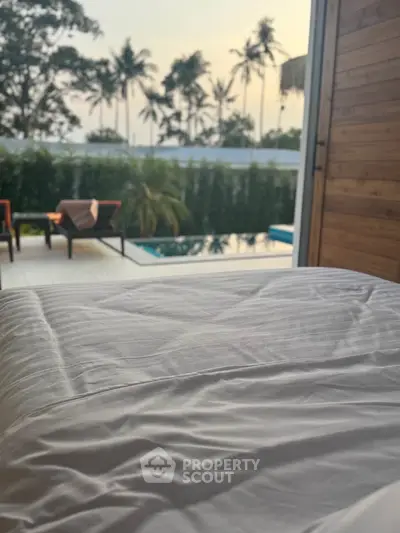 Luxurious bedroom with pool view and tropical surroundings, perfect for relaxation and tranquility.