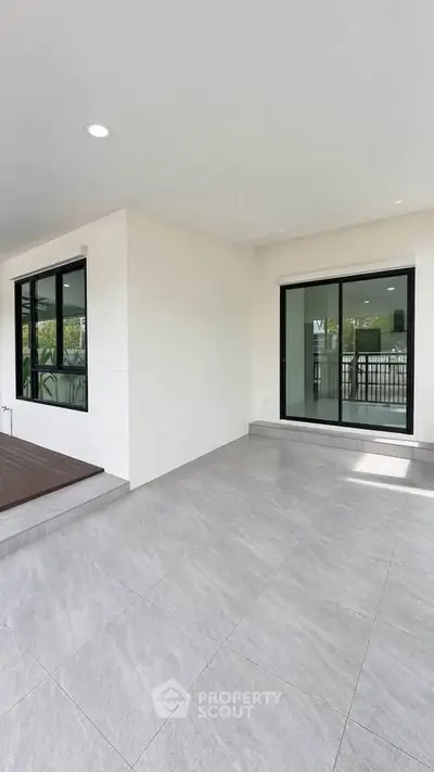 Spacious modern balcony with sliding glass doors and elegant flooring
