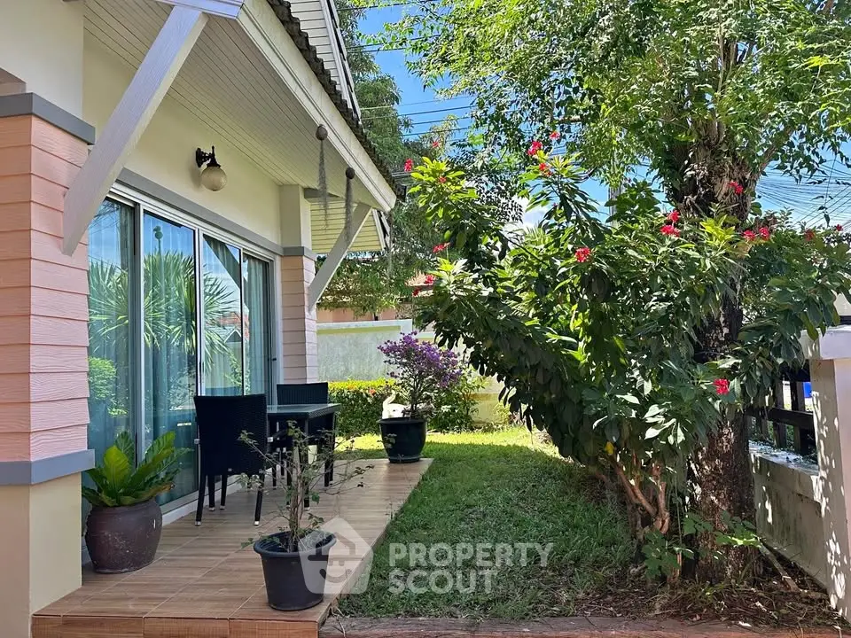 Charming garden patio with lush greenery and cozy seating area, perfect for relaxation.