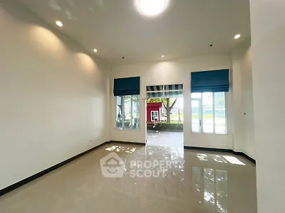 Spacious room with large windows and glossy floor, offering a bright and airy atmosphere.