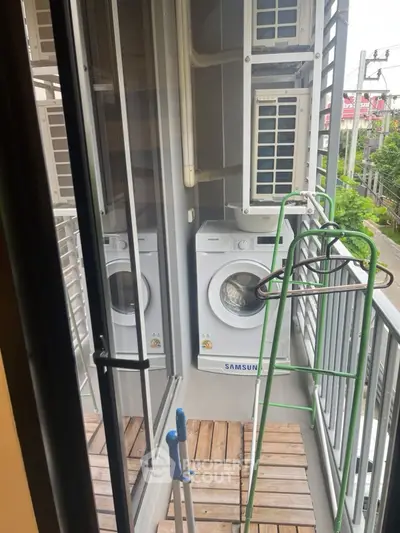 Compact balcony with washing machine and air conditioning units, ideal for urban living.