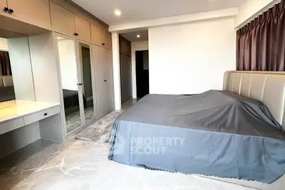 Spacious bedroom with modern built-in wardrobe and elegant marble flooring.