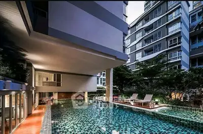 Luxurious condominium with modern pool and stylish architecture, perfect for urban living.