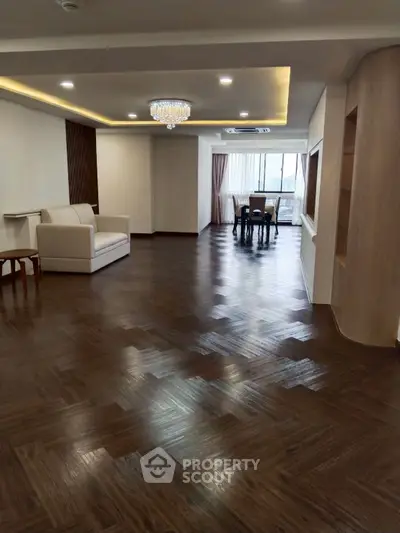 Spacious modern living room with elegant chandelier and wooden flooring