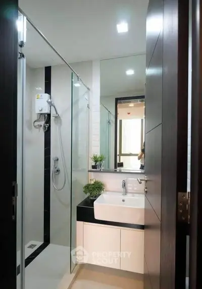 Modern bathroom with glass shower and sleek vanity in a contemporary apartment.