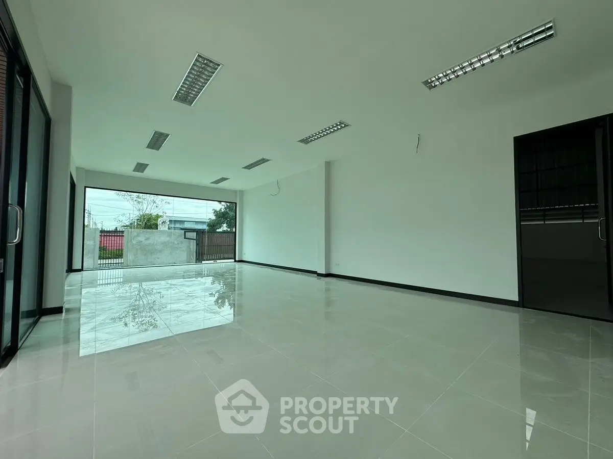 Spacious modern living room with large windows and sleek tile flooring