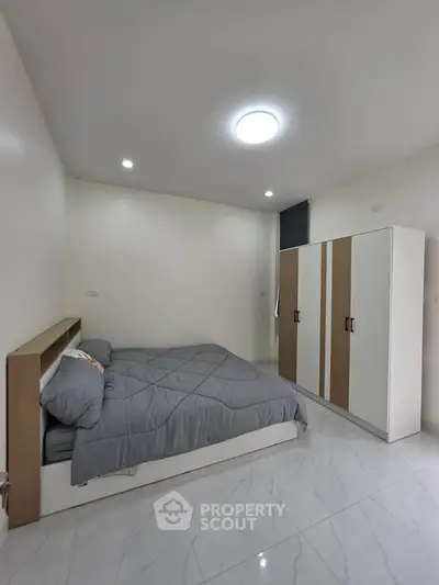 Modern bedroom with sleek design and ample storage in a stylish apartment.