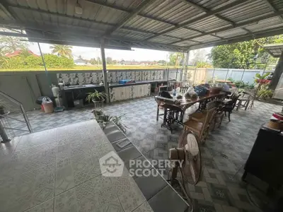 Spacious outdoor kitchen with dining area and garden view, perfect for entertaining.