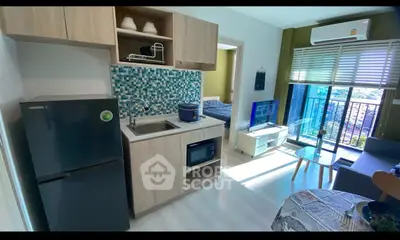 Modern open-layout kitchen and living area with balcony view in stylish apartment.