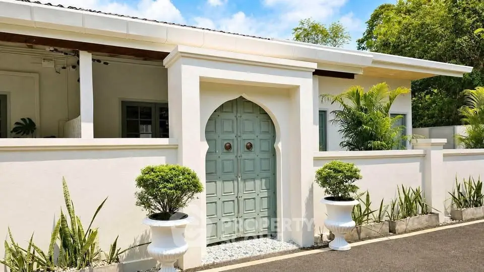 Charming villa entrance with elegant archway and lush greenery, showcasing Mediterranean architectural style.