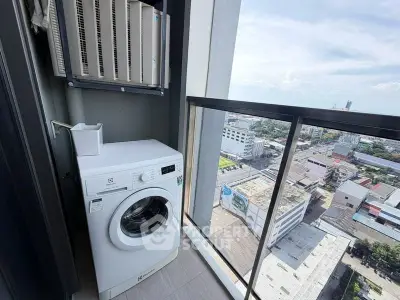 High-rise balcony with washing machine and city view, perfect for urban living.