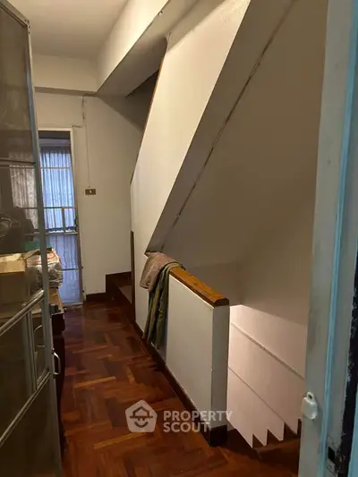 Charming interior staircase with wooden flooring and natural light