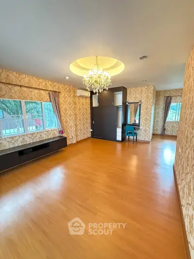 Spacious living room with elegant chandelier and wooden flooring