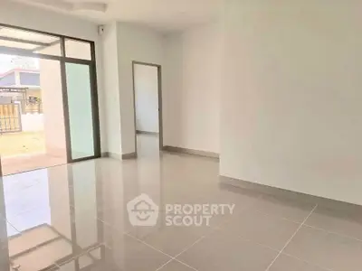 Spacious and bright living room with large windows and modern tile flooring.