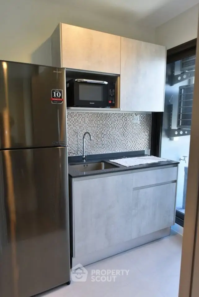 Modern compact kitchen with sleek appliances and stylish backsplash