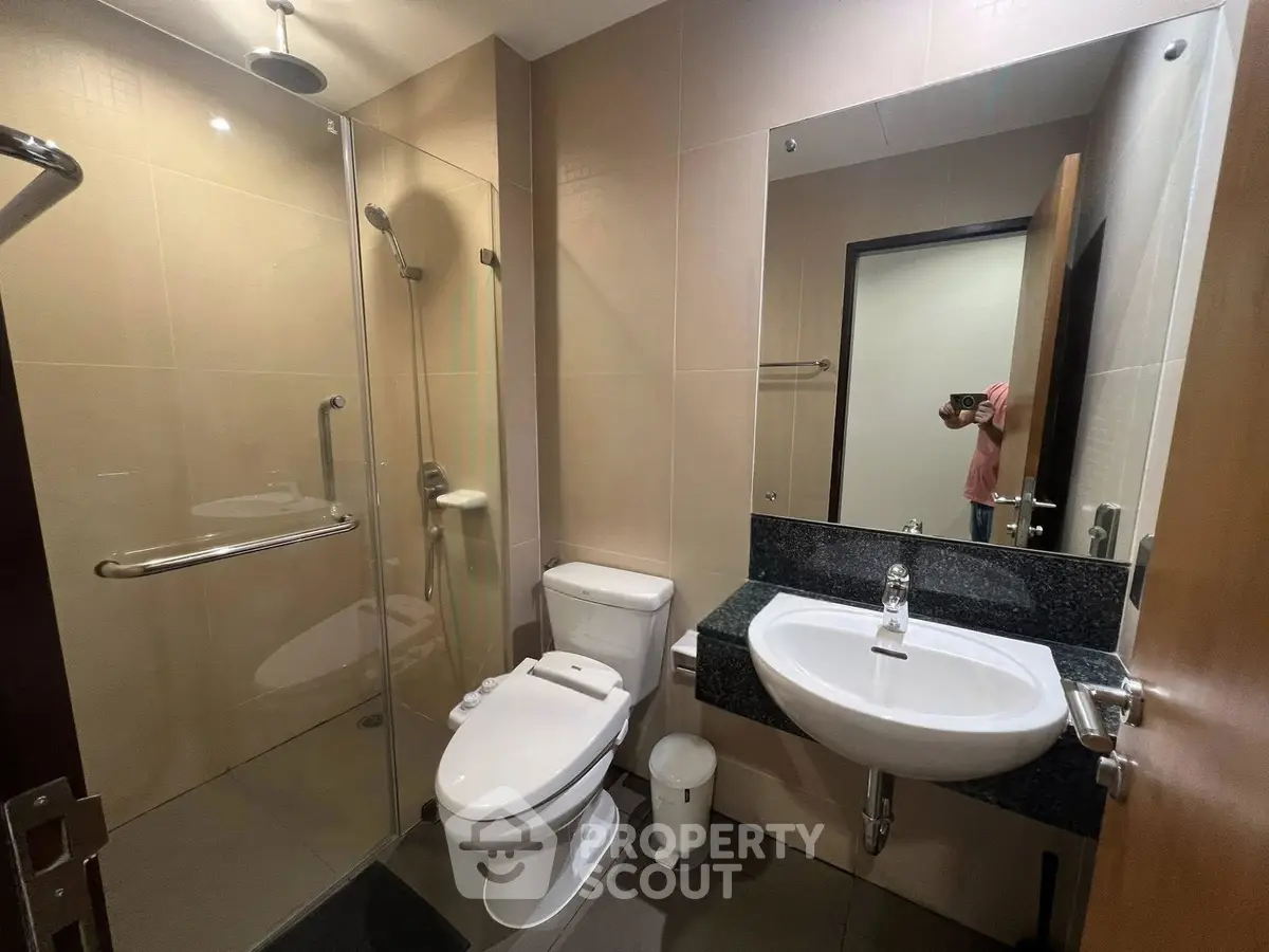 Modern bathroom with glass shower and sleek fixtures in a contemporary home.