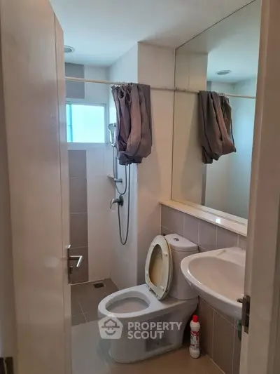 Compact bathroom with modern fixtures and natural light from window